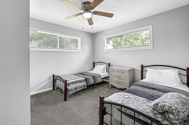 bedroom featuring a textured ceiling, dark colored carpet, and ceiling fan