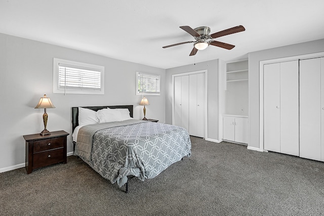 carpeted bedroom featuring ceiling fan and multiple closets