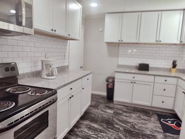 kitchen with light stone counters, white cabinets, tasteful backsplash, appliances with stainless steel finishes, and dark hardwood / wood-style floors