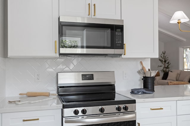 kitchen with backsplash, white cabinetry, and stainless steel appliances