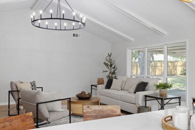 living room with an inviting chandelier, lofted ceiling with beams, and hardwood / wood-style floors