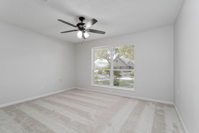 carpeted spare room with a textured ceiling and ceiling fan