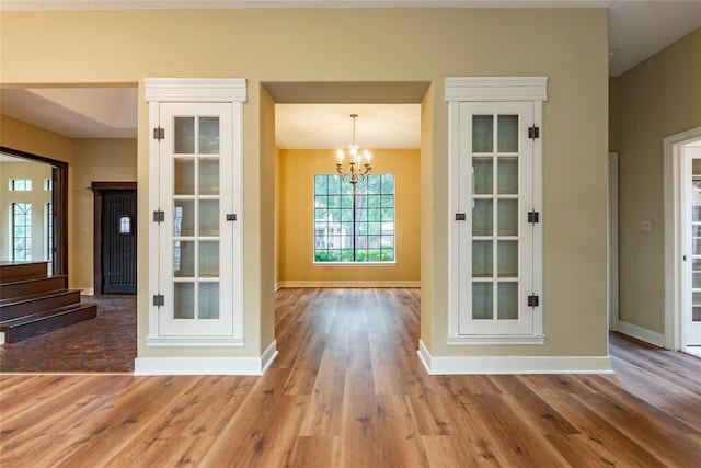 interior space with wood-type flooring and a chandelier