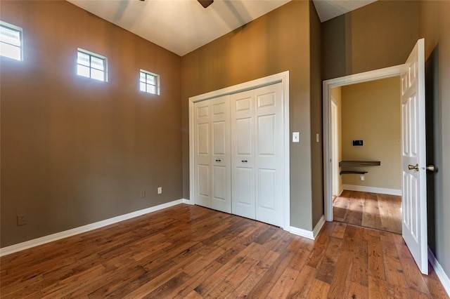 unfurnished bedroom featuring wood-type flooring, a closet, and ceiling fan