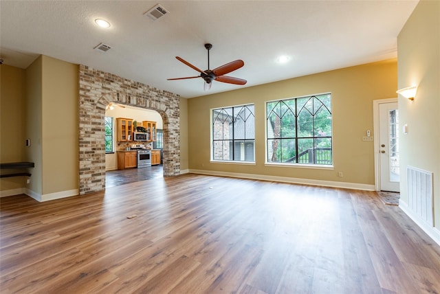 unfurnished living room with a textured ceiling, ceiling fan, and hardwood / wood-style flooring