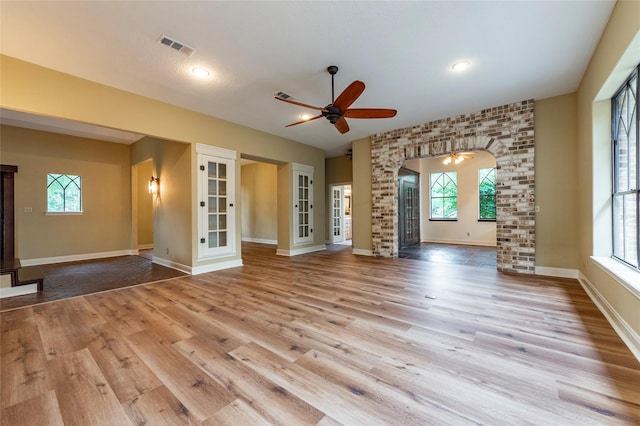 unfurnished living room featuring ceiling fan and light wood-type flooring