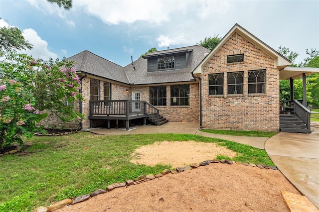 rear view of house with a lawn and a deck