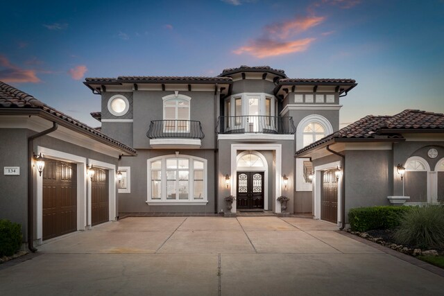 mediterranean / spanish-style home featuring a balcony and french doors