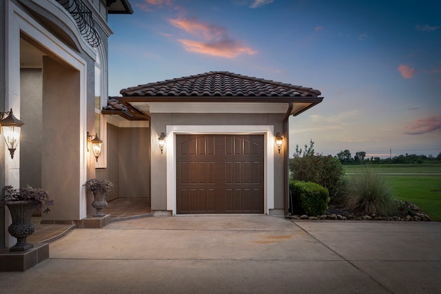 view of garage at dusk