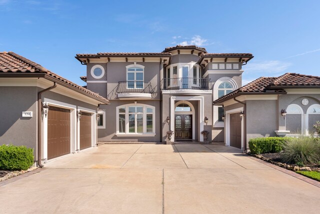 mediterranean / spanish-style house with a balcony and a garage