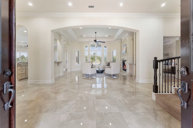 entryway featuring ornamental molding and a raised ceiling