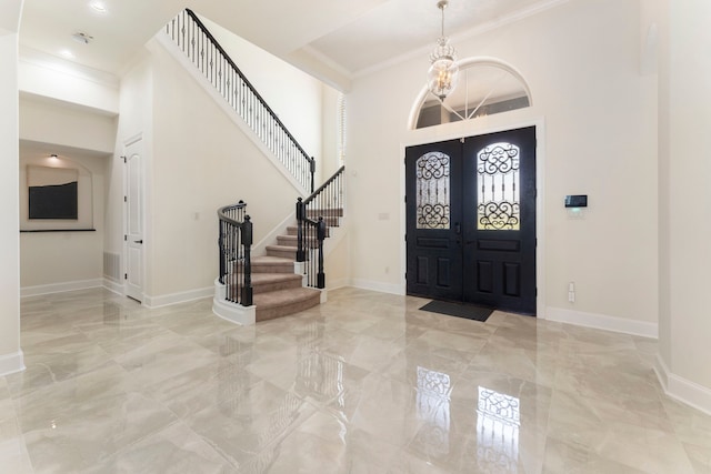 foyer with ornamental molding and french doors