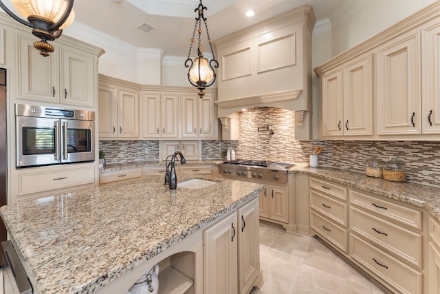 kitchen featuring hanging light fixtures, cream cabinetry, and light stone countertops