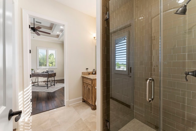 full bathroom featuring a raised ceiling, a ceiling fan, crown molding, vanity, and a shower stall