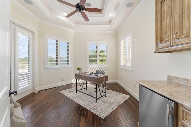 office area with ornamental molding, dark wood-type flooring, a tray ceiling, and ceiling fan