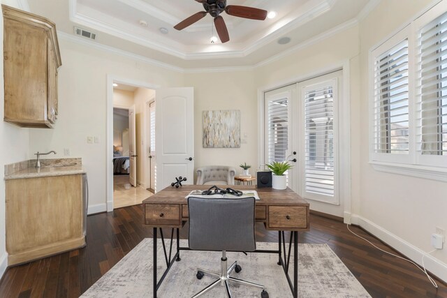 office space with dark hardwood / wood-style flooring, ornamental molding, a raised ceiling, and a wealth of natural light