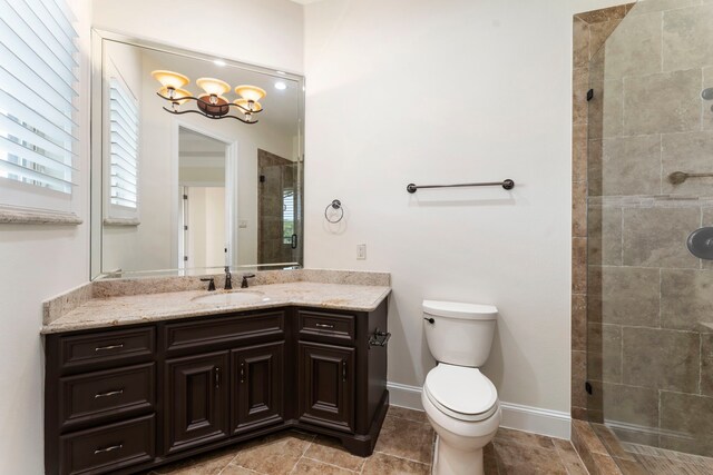 bathroom featuring vanity, toilet, and tiled shower