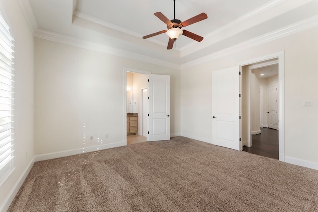 unfurnished bedroom with ornamental molding, a raised ceiling, carpet floors, and ceiling fan