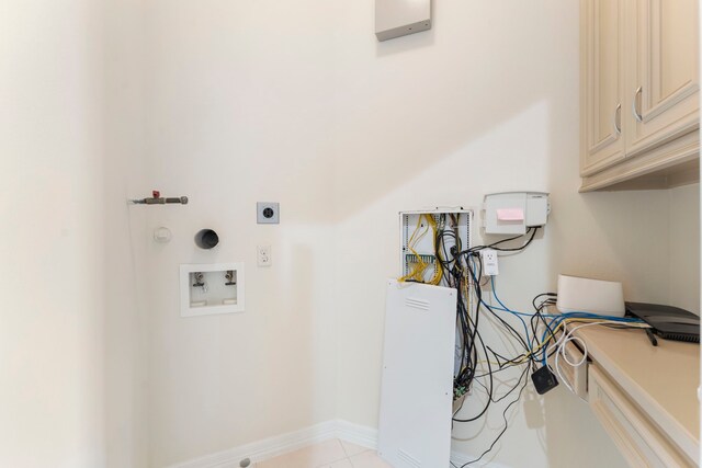 washroom featuring hookup for an electric dryer, washer hookup, light tile patterned floors, and cabinets