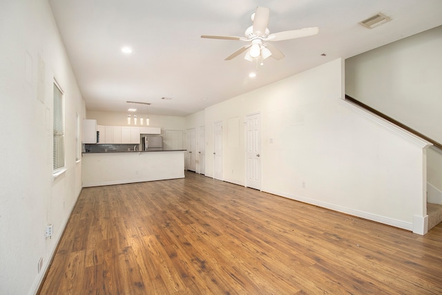 unfurnished living room featuring ceiling fan and wood-type flooring