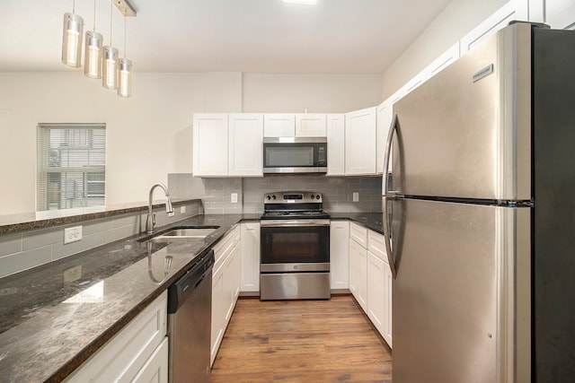 kitchen with white cabinets, light hardwood / wood-style floors, appliances with stainless steel finishes, and sink