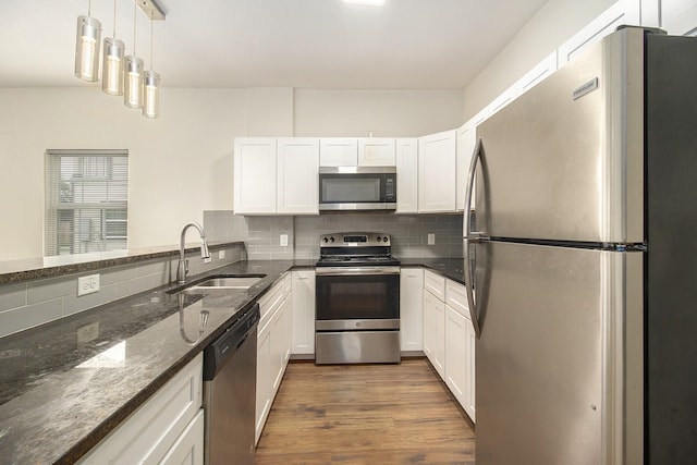 kitchen featuring a sink, wood finished floors, white cabinets, and stainless steel appliances