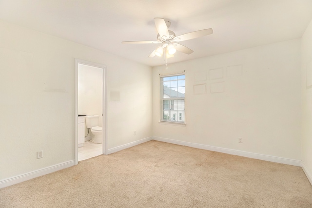 unfurnished bedroom featuring ceiling fan, connected bathroom, and light carpet