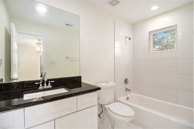 full bathroom featuring ceiling fan, tiled shower / bath combo, vanity, and toilet