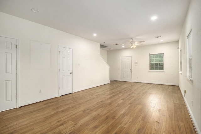 unfurnished room with ceiling fan, visible vents, wood finished floors, baseboards, and recessed lighting