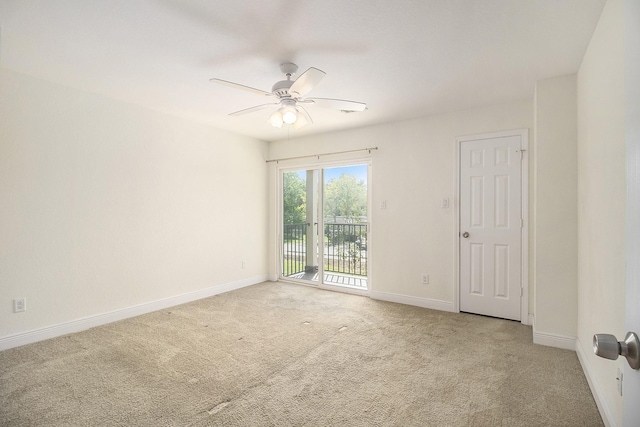 spare room with a ceiling fan, baseboards, and light carpet