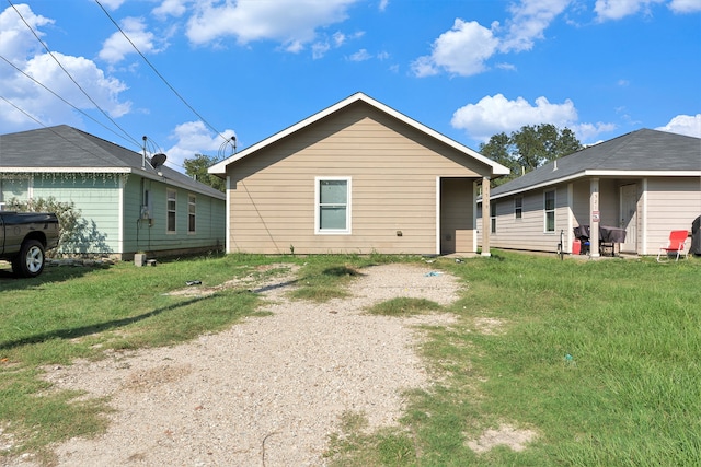 rear view of property featuring a yard