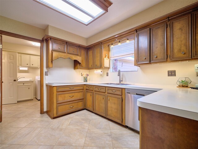 kitchen featuring washing machine and dryer, dishwasher, light tile patterned floors, and sink