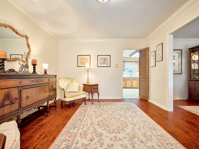 living area featuring hardwood / wood-style flooring, crown molding, and a textured ceiling