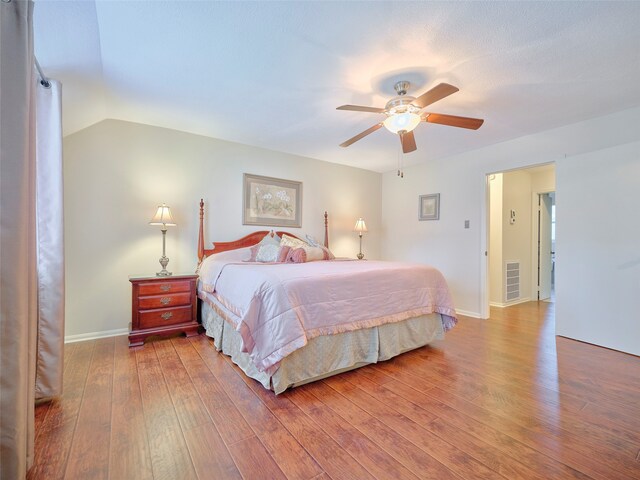 bedroom with hardwood / wood-style floors, ceiling fan, and lofted ceiling