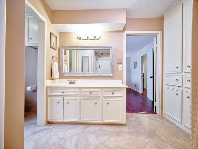 bathroom featuring hardwood / wood-style floors, vanity, and a textured ceiling