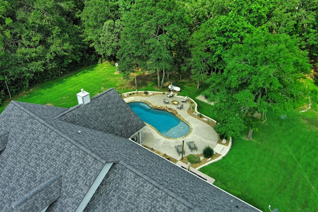 view of swimming pool featuring a yard