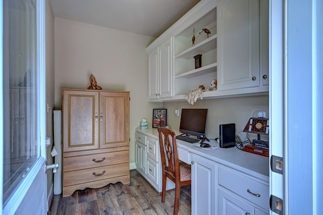 office space featuring light hardwood / wood-style flooring and built in desk