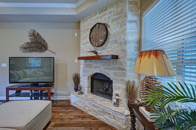 living room featuring hardwood / wood-style flooring, a fireplace, and crown molding