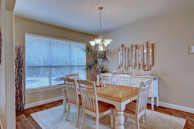 dining area with an inviting chandelier and hardwood / wood-style floors