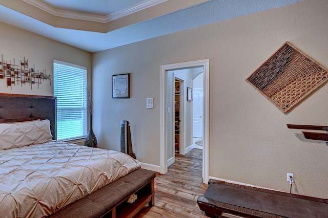 bedroom with ornamental molding and light hardwood / wood-style floors