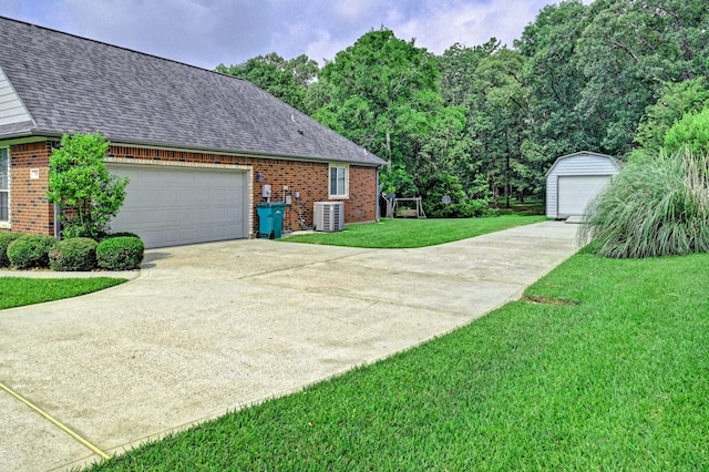 view of side of home with a lawn, a garage, and central air condition unit