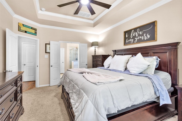 bedroom featuring visible vents, light colored carpet, a tray ceiling, and ornamental molding