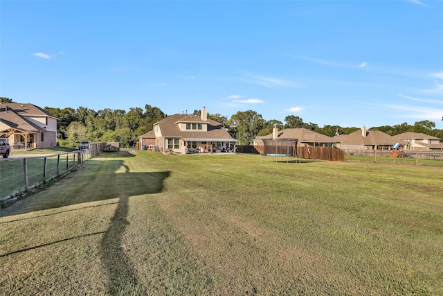 view of yard with a trampoline and a fenced backyard