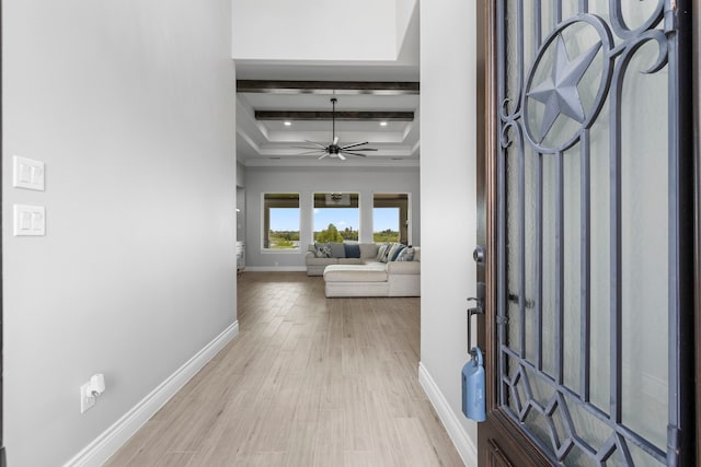 foyer with light hardwood / wood-style floors, coffered ceiling, ceiling fan, and beamed ceiling