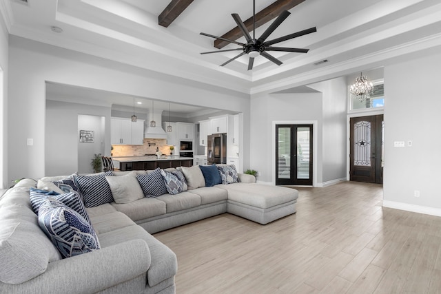 living room featuring beamed ceiling, crown molding, ceiling fan with notable chandelier, a towering ceiling, and light hardwood / wood-style floors