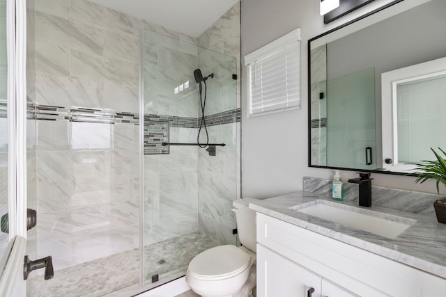 bathroom with vanity, toilet, and a shower with shower door