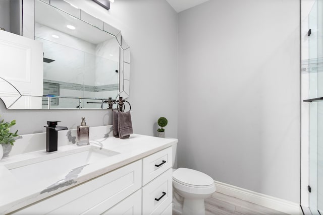 bathroom featuring walk in shower, vanity, toilet, and hardwood / wood-style flooring