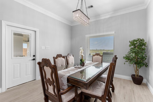 dining area featuring ornamental molding, a chandelier, and light hardwood / wood-style floors