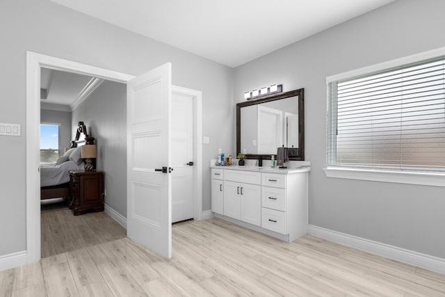 bathroom with ornamental molding, vanity, and hardwood / wood-style floors