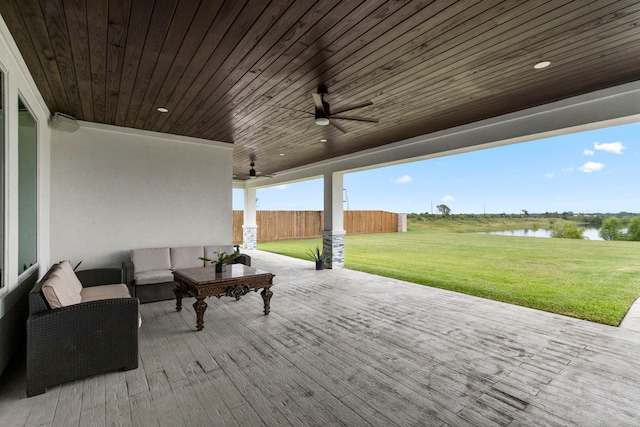 exterior space featuring a lawn, a water view, and outdoor lounge area